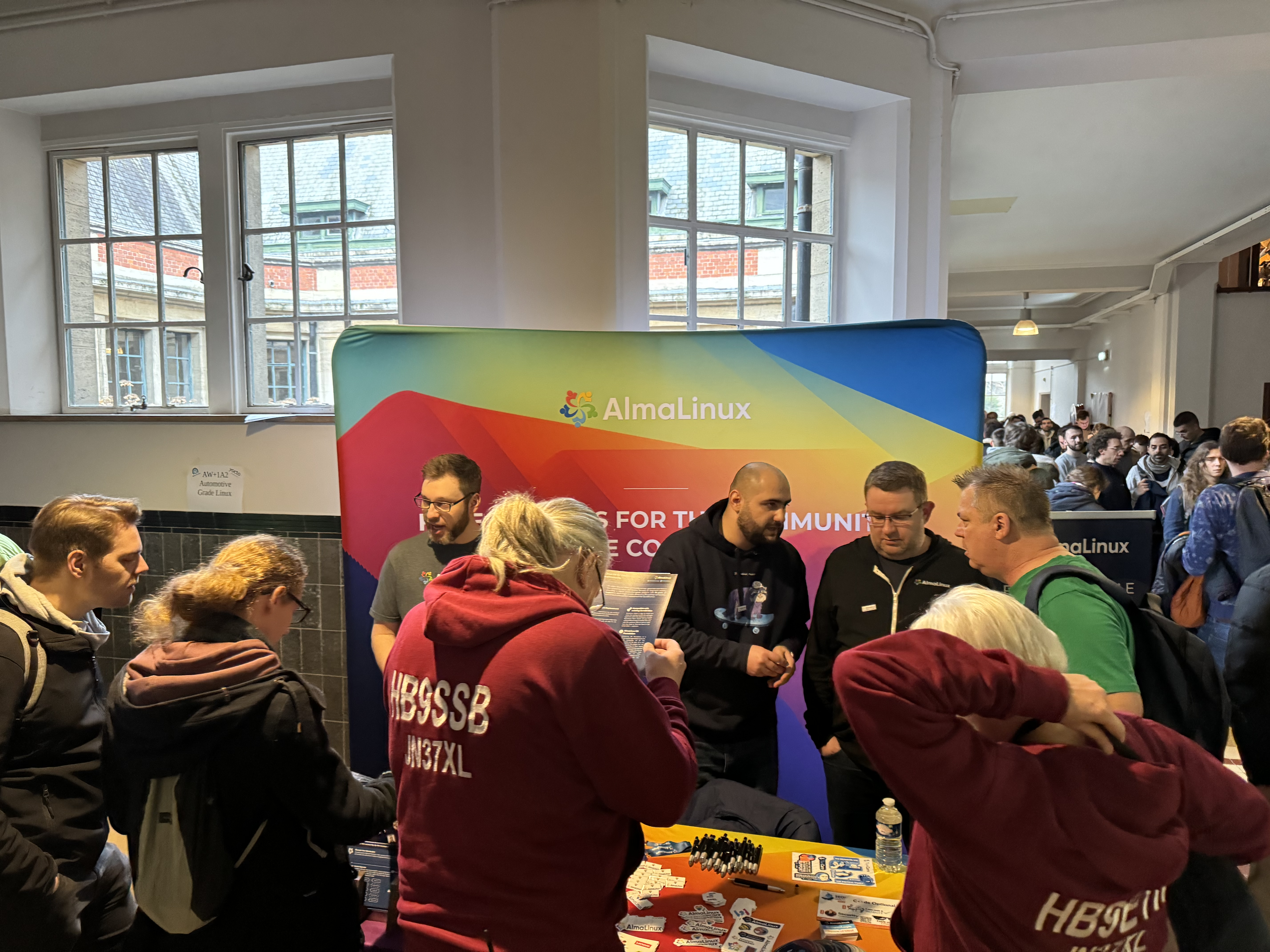 Andrew, Jonathan, and Elkin at our FOSDEM booth with a crowd