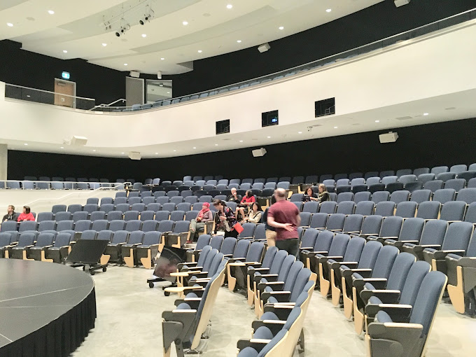 a collection of people sitting at a table with laptopls in front of them
